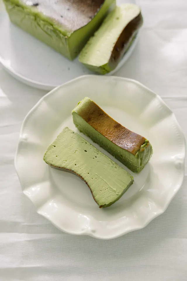 Matcha cheesecake slices on a wavy white plate